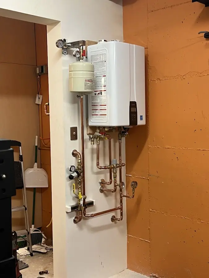 Plumbing technician inspecting water heater connections in Sidney